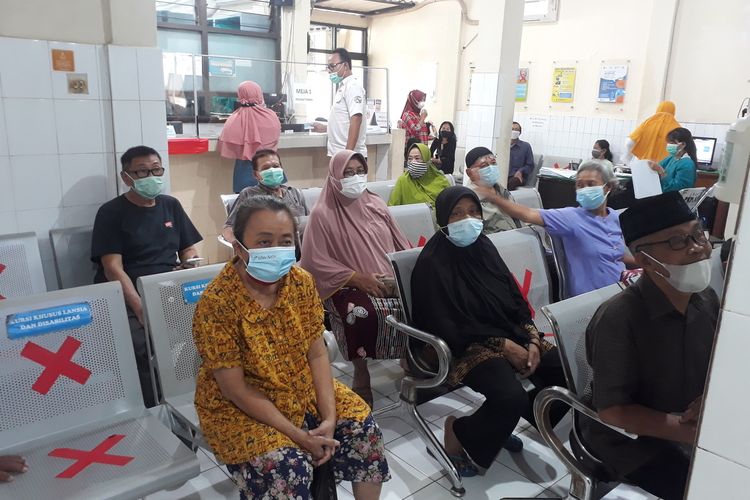 Sejumlah warga lansia melakukan pendaftaran pada pelaksanaan vaksin perdana bagi lansia di Puskesmas Kedungdoro, Surabaya, Jawa Timur, Selasa (23/2/2021).(KOMPAS.COM/GHINAN SALMAN)